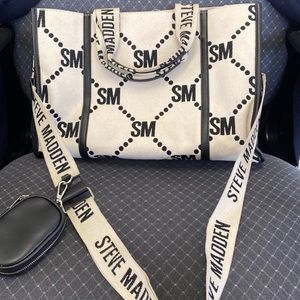 A cream and black cloth material Steven Madden bag vinyl on the inside